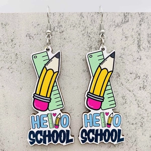 Close-up of Hello School pencil and ruler drop earrings with vibrant colors on grey display