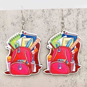 Detailed close-up of wooden student earrings featuring a creative red schoolbag illustration
