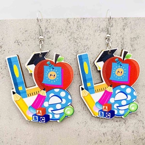 Macro detail of wooden hook earrings with colorful LOVE school and teacher themed design