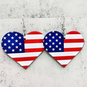 Detailed close-up of heart-shaped USA flag earrings with silver fishhook wires