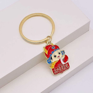 Detail of cartoon scholar graduation keychain with golden Success text and enamel finish