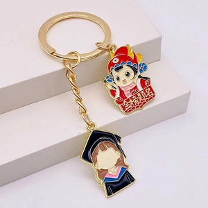 Detail of metal enamel graduation keychain with doctoral cap and scholar charms
