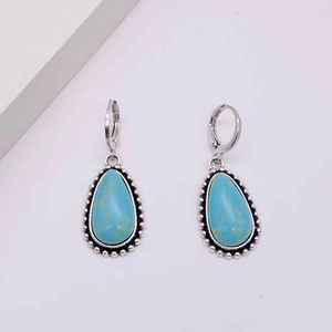 Detail of bohemian turquoise teardrop earrings with vintage silver beaded metal edges