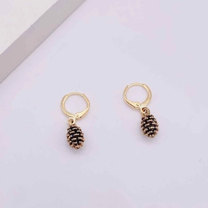 Detail of vintage gold huggie hoop earrings with detailed pine cone pendant drops