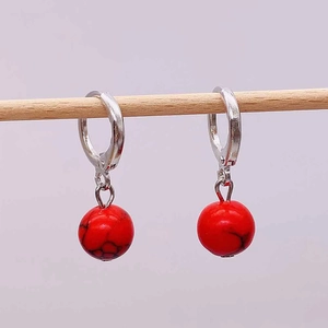 Retro silver hoop earrings with red marble textured round stone charms on wood display