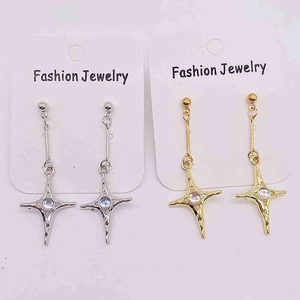 Détail de boucles d'oreilles longue chaîne avec pendentifs étoile à quatre branches
