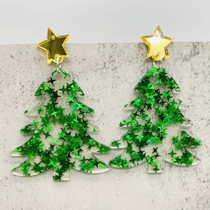 Detailed macro view of acrylic Christmas tree earrings with green glitter and gold stars