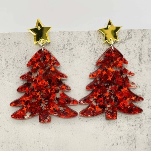Detail of red glitter Christmas tree earrings with gold star studs and shiny sequins
