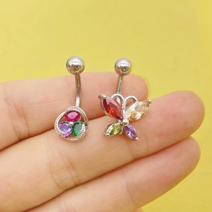 Macro detail of silver stainless steel navel rings with butterfly and floral zircon charms