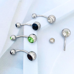 Macro detail of multicolored double crystal navel rings in polished stainless steel finish