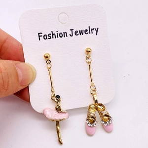 Détails des boucles d'oreilles ballerine rose et chaussons à strass asymétriques