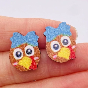 Close-up of a colorful cartoon owl wooden earring showing detailed texture and size