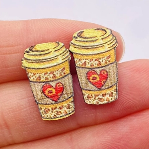 Detail of wooden leopard print coffee cup earrings with heart pattern and yellow lid