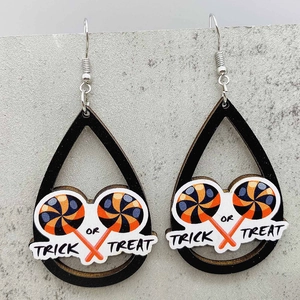 Dettaglio di orecchini Halloween con testo Trick or Treat e design di lecca