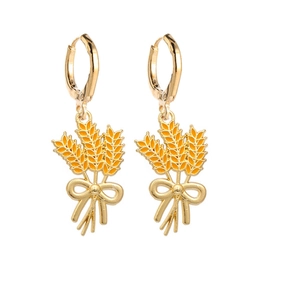 Detailed view of golden wheat stalk drop earrings with yellow enamel and butterfly bow
