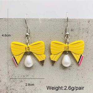 Pencil-shaped bow earrings with acrylic heart charm and white faux pearl drop