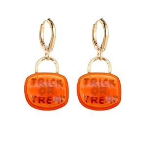 Detail of orange Trick or Treat earrings with golden hoops for Halloween style