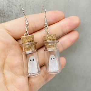 Detalle de pendientes hechos a mano de fantasmas de Halloween en botellas de vidrio mini