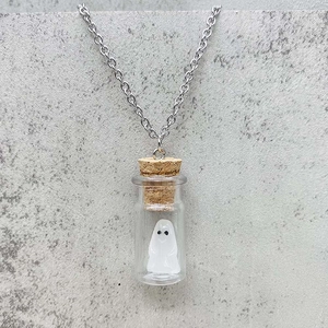Detalle de figura de fantasma de Halloween en un colgante de botella de cristal con corcho