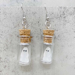 Detalle de fantasmas luminosos 3D en botellas de vidrio para pendientes Halloween