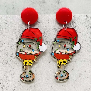 Macro view of acrylic red wine glass earrings with Christmas hat and colorful light print