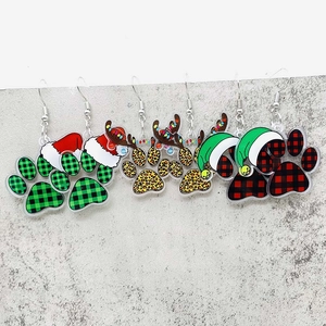 Detailweergave van drie paar acryl kerstoorbellen met feestelijke kattenpootafdrukken