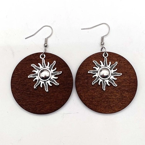 Bohemian style deep brown wooden earrings with silver sunburst patterns and metal hooks