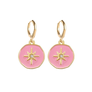 Detail of pink enamel starburst earrings with sparkling center stone and gold hoops