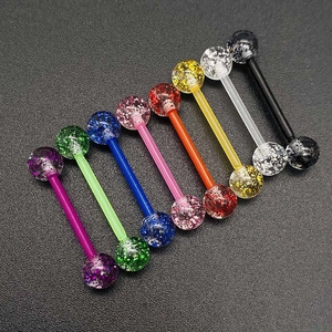 Gros plan d'un ensemble de piercings de langue en acrylique coloré avec boules pailletées