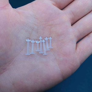 Set of seven clear acrylic labret studs for cartilage and ear piercing held in hand