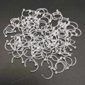 Macro shot of bulk transparent acrylic C-shape rings for nose and ear piercings
