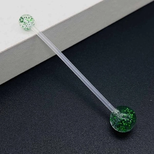 Detail view of flexible industrial barbell with green glitter acrylic ball ends for piercing