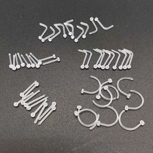 Macro view of transparent acrylic piercing set including nose rings and studs