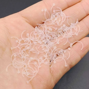 Transparent acrylic retainer studs for nose and ear piercings held in hand