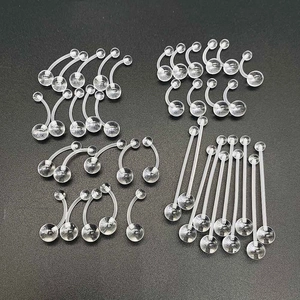 Set of clear acrylic belly rings and body piercing jewelry shown on black background