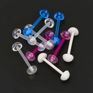 Vue détaillée de piercings de langue en acrylique coloré avec paillettes sur fond noir