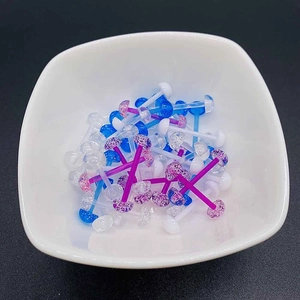 Piercings de langue et tétons en acrylique pailleté coloré dans un bol blanc