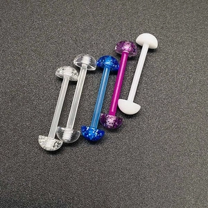 Vue détaillée de cinq bijoux de piercing en acrylique coloré avec finitions pailletées et claires
