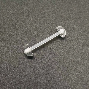 Vue détaillée du piercing de langue en acrylique clair avec barre et boules
