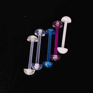 Gros plan de piercings de langue en acrylique souple coloré avec finitions pailletées