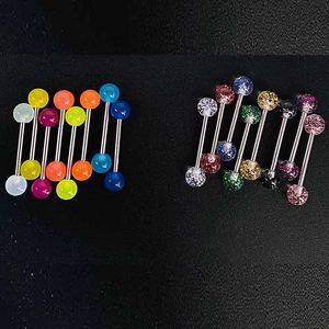 Gros plan de piercings en acrylique coloré avec paillettes et boules fluo sur fond sombre