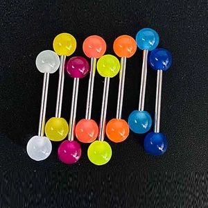 Ensemble de piercings langue et téton en acrylique coloré et acier sur fond noir mat