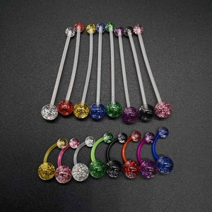 Close-up of colorful acrylic belly rings with glitter sequins on a textured surface