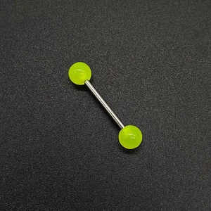 Gros plan sur le piercing en acrylique vert fluo avec barre en acier poli