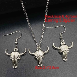 Makroaufnahme von silbernem Stierkopf-Schmuckset mit detaillierter Kette und Ohrringen