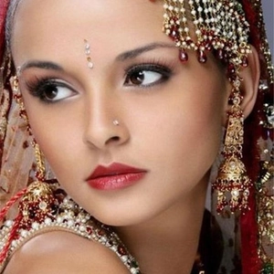 Conjunto de joyas indias tradicionales doradas con gemas rojas y perlas en modelo