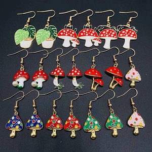 Détails des boucles d'oreilles champignons en émail à pois rouges et crochets dorés