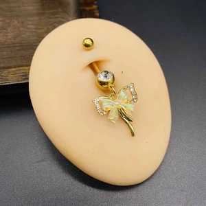 Golden stainless steel belly ring with bow pendant and sparkling crystals on skin model