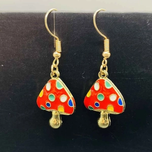 Détail des boucles d'oreilles champignons en émail coloré avec des crochets dorés