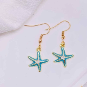 Detailed view of ocean style starfish earrings with blue enamel and gold finish